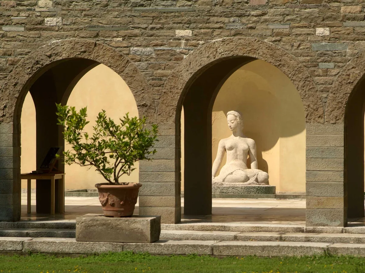 Il portico ad archi di Villa Ottolenghi con una scultura e una pianta di agrumi
